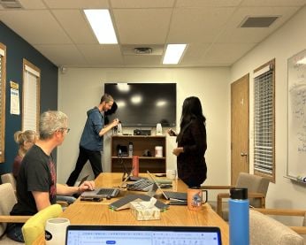 eServices staff in a boardroom setting up for a meeting.