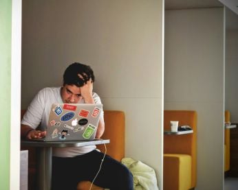 Frustrated person using their laptop.