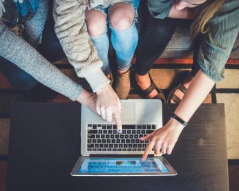 People on a couch looking at a laptop together