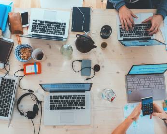 Laptops open on a boardroom table