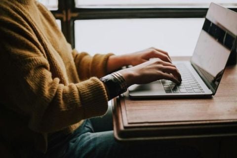 Gros plan d’une personne en train d’écrire sur un ordinateur portable