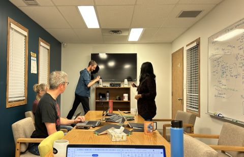 eServices staff in a boardroom setting up for a meeting.