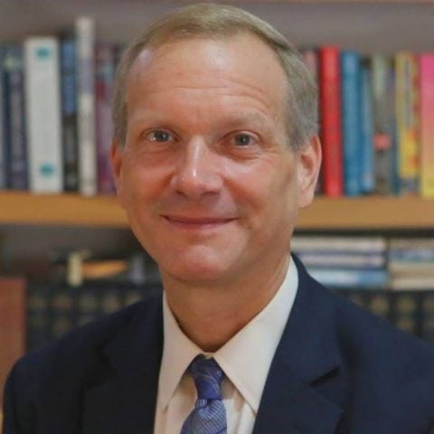 Greg Newby in a suit and tie