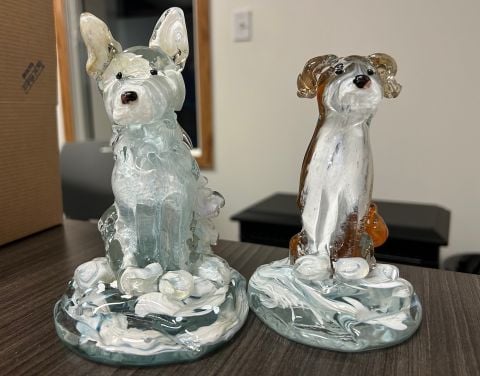 Two glass-blown dogs. On the left is a white husky called Moose and on the right is a floppy-eared husky called Floppy.