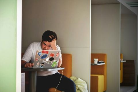 Frustrated person using their laptop.