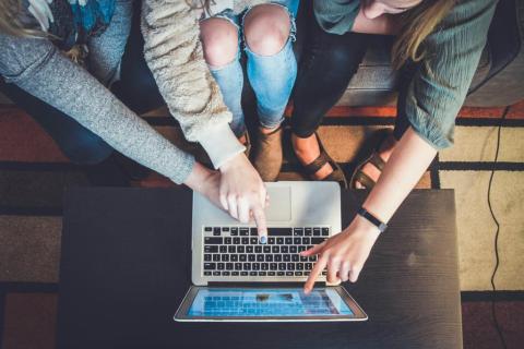 People on a couch looking at a laptop together