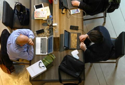 Aerial view of people at a table working on their laptops