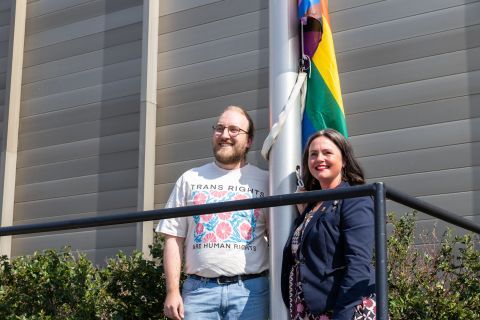 Executive director of Queer Yukon Society Niall Janssen and Minister responsible for the Women and Gender Equity Directorate Laura Lang pose ahead of the flag raising ceremony on August 12, 2026, at the Jim Smith Building in Whitehorse.