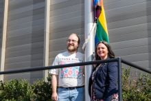 Executive director of Queer Yukon Society Niall Janssen and Minister responsible for the Women and Gender Equity Directorate Laura Lang pose ahead of the flag raising ceremony on August 12, 2026, at the Jim Smith Building in Whitehorse.