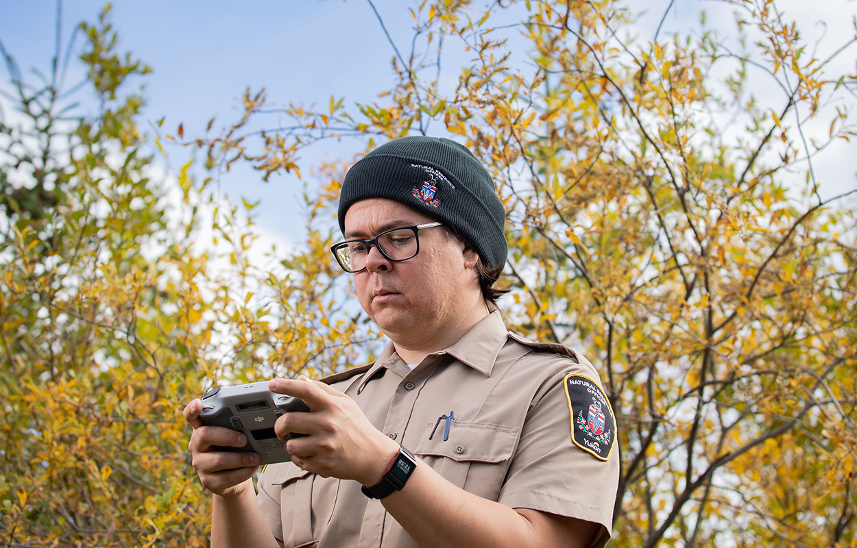  A natural resource officer looking at a drone controller.