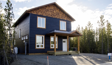 A freestanding 2 storey dark blue home in Whistle Bend.