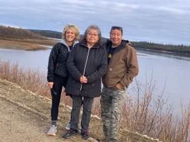 Kelly Allen, Elder Dianne Smith and Joe Migwans stand in front of the water. 